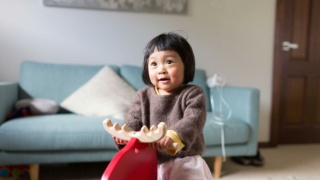 Young girl play riding wooden reindeer