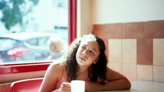 Teenage girl in a café with a cup of tea