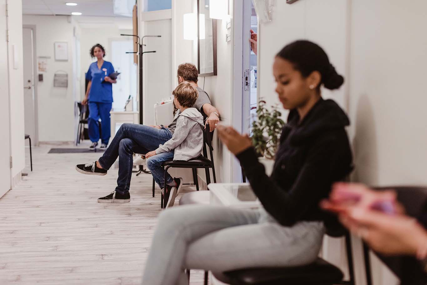 Male and female patients waiting in corridor of medical centre
